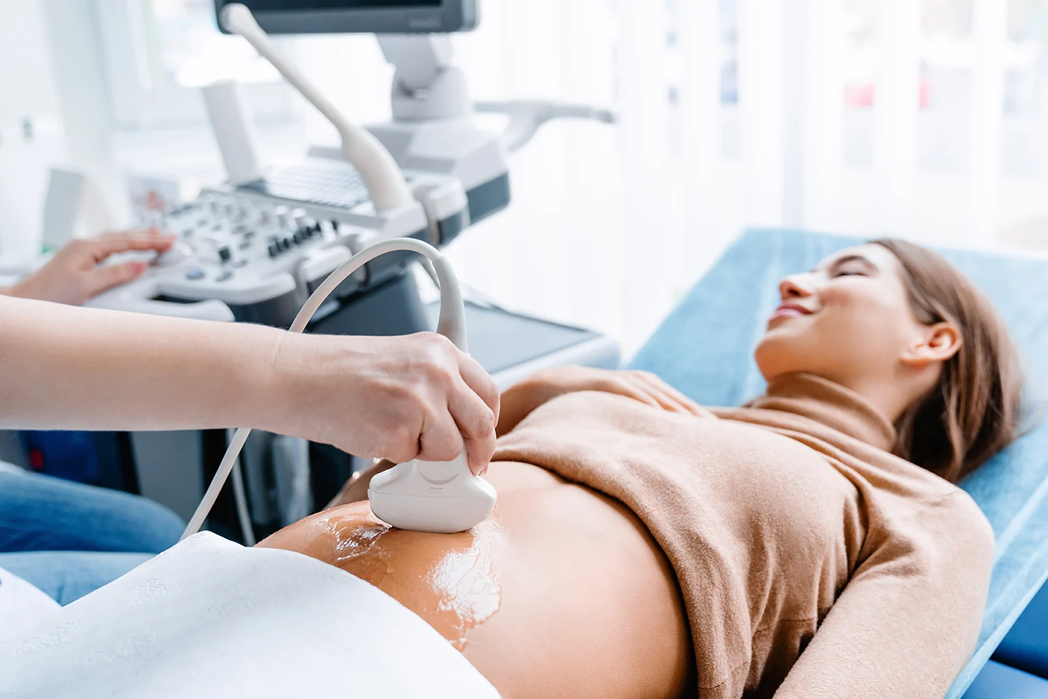 Doctor hand with ultrasonic during ultrasound medicine examination of pregnant patient. Maternity, pregnancy, fertility concept. Future mom checking on the embryo